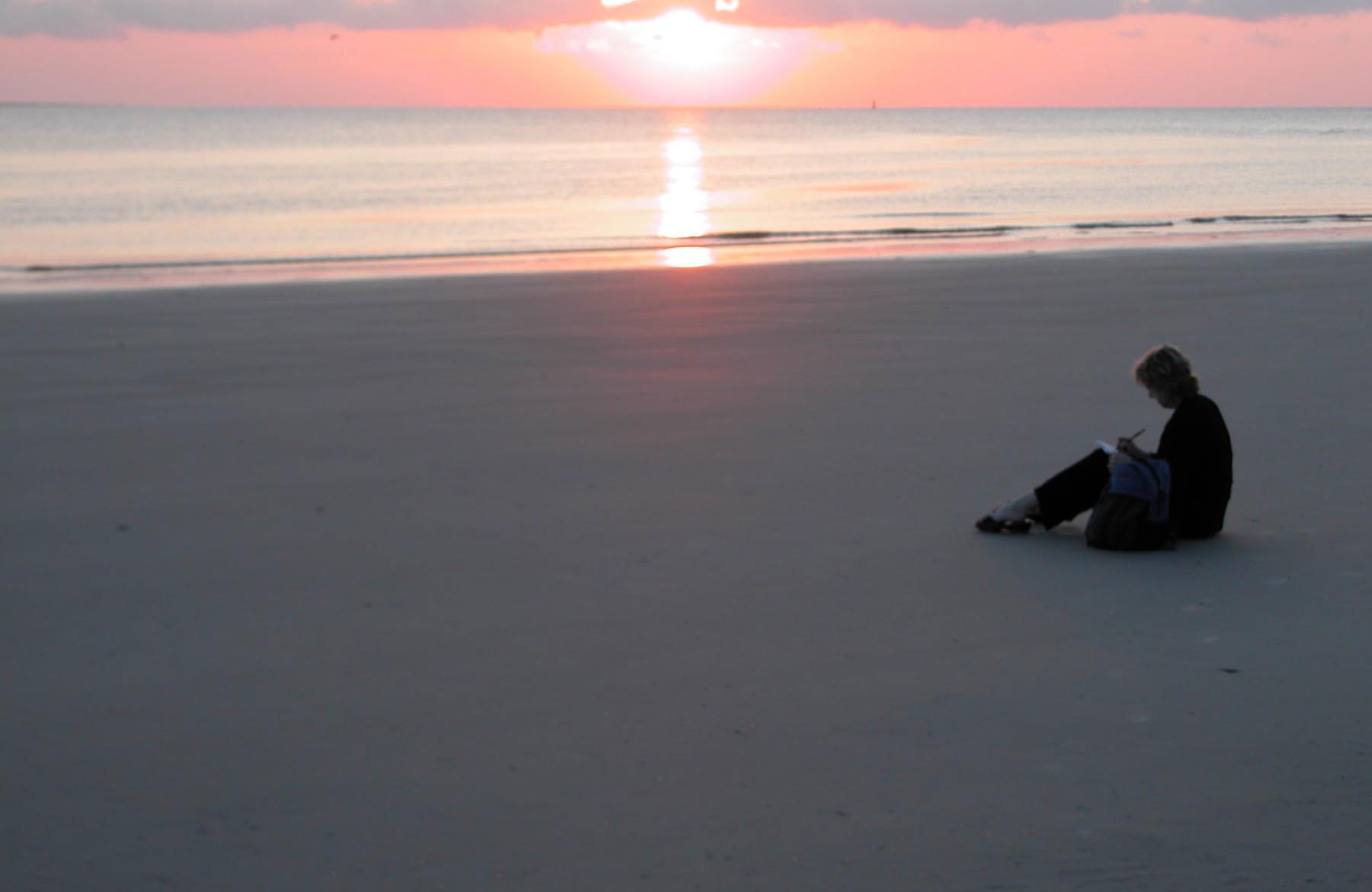 Maureen Glass writing on the beach